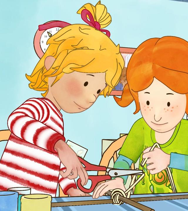 Conni (links) bastelt mit Anna (rechts) einen Drachen. Anna umwickelt die beiden Holzstangen mit Kordel, Conni schneidet mit der Schere.