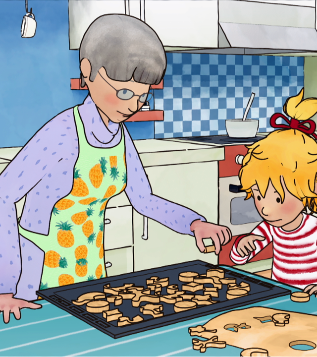 Conni und Simon backen Plätzchen. Connis Oma hilft dabei, die Plätzchen auf das Backblech zu legen.