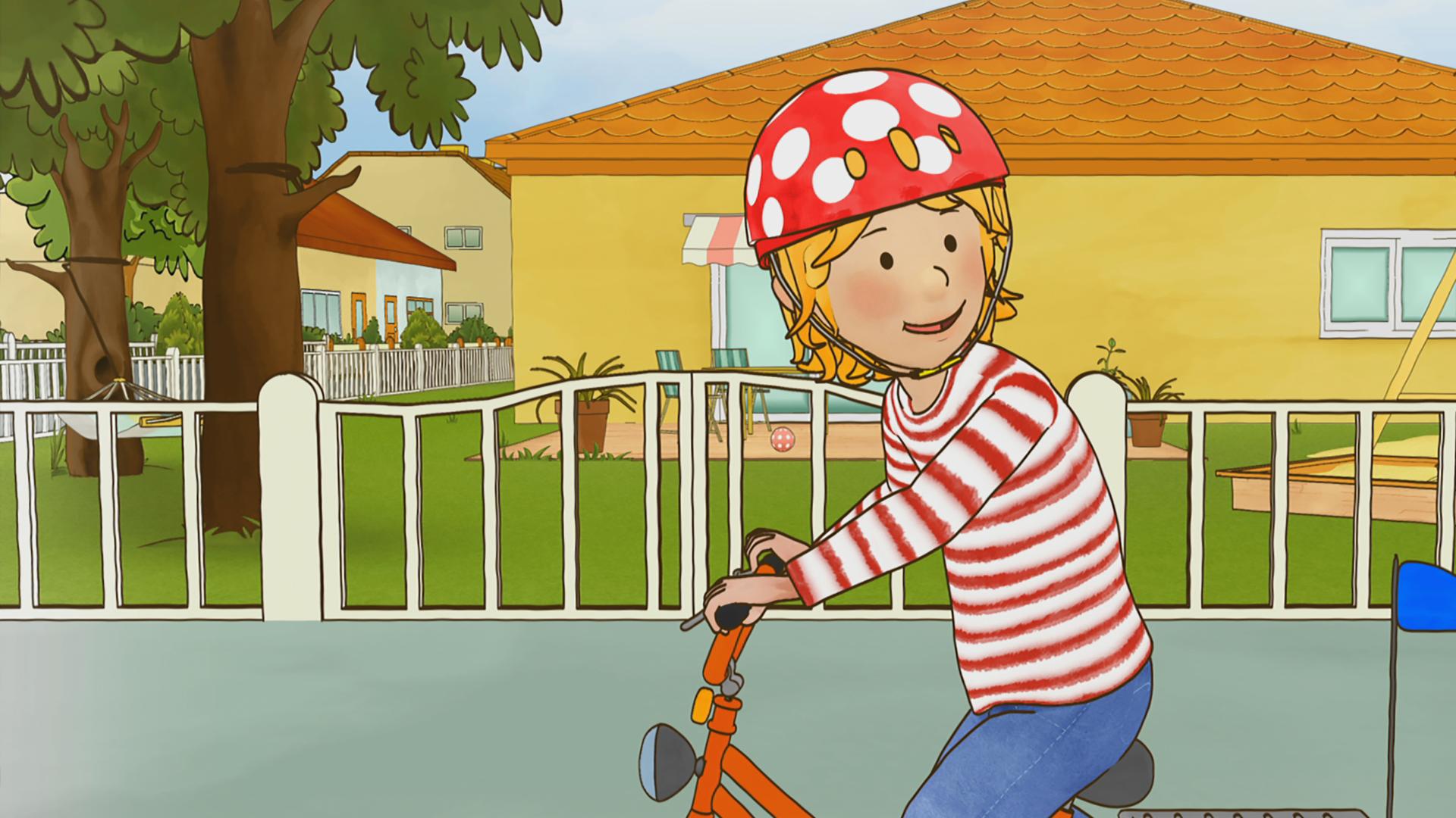 Conni sitzt mit Helm auf ihrem Fahrrad und übt den Schulterblick.