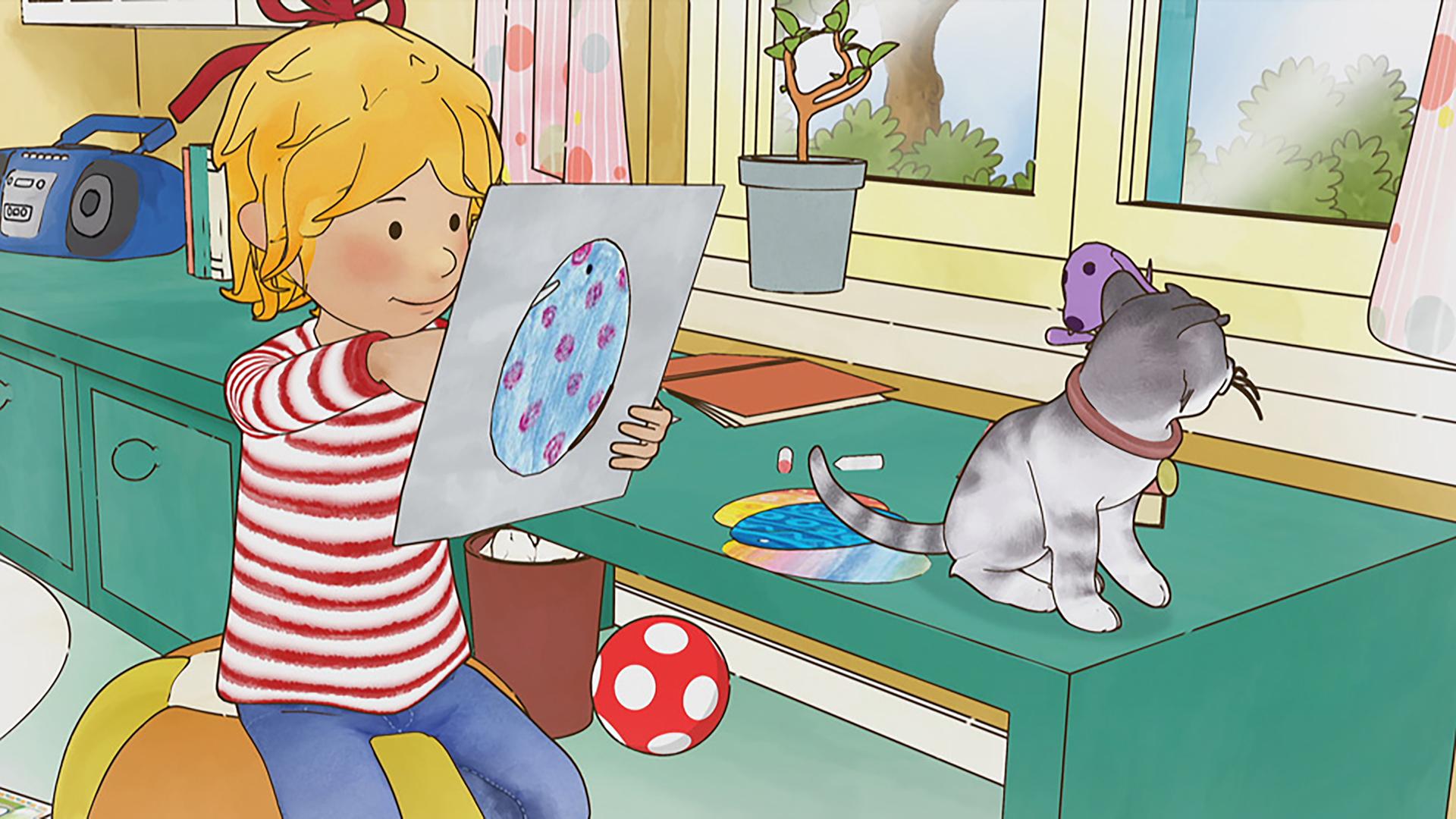 Conni bemalt Ostereier. Neben ihr sitzt eine Katze auf dem Tisch und schaut durch das Fenster nach draußen.