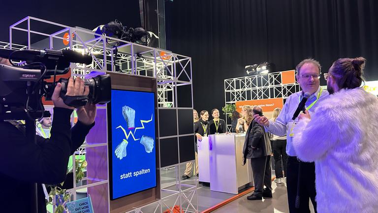 ZDF-Digitalexperte Robert Amlung wird im Gespräch vor dem ZDF-Stand auf der ConCon25 gefilmt