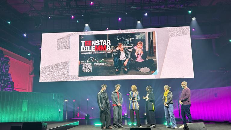 Auf der ConCon-Bühne: Vanessa Olivier, Head of Strategische Formatentwicklung im ZDF, (2.v.r.) sprach mit den HE/RO-Musikern Roman und Heiko Lochmann, Produzent Eric Winker und Regisseurin Carolin Genreith über die ZDF-Doku-Serie "Teenstar Dilemma"