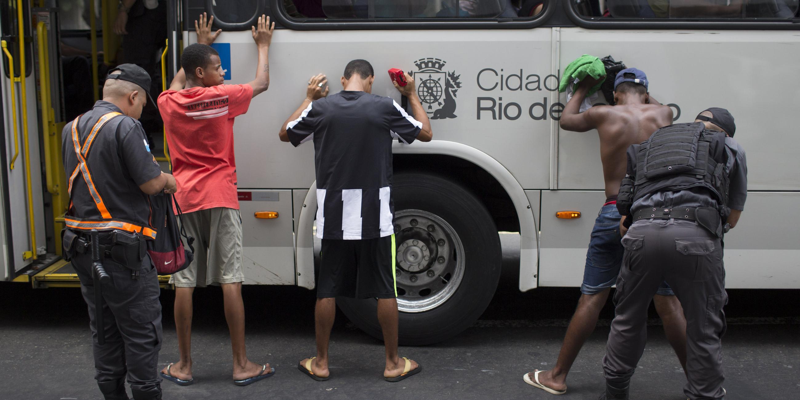 Polizeibeamte kontrolliern Busreisende in Rio de Janeiro.
