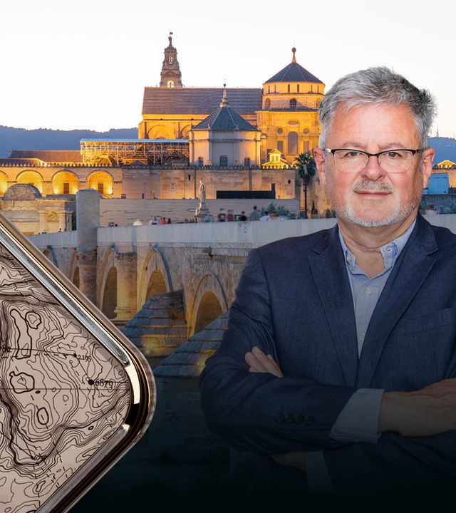 Blick auf die bei Dämmerung beleuchtete Römische Brücke in Cordoba mit ihren schönen Torbögen und der dahinterliegenden Altstadt. Rechts im Vordergrund Christopher Clark.