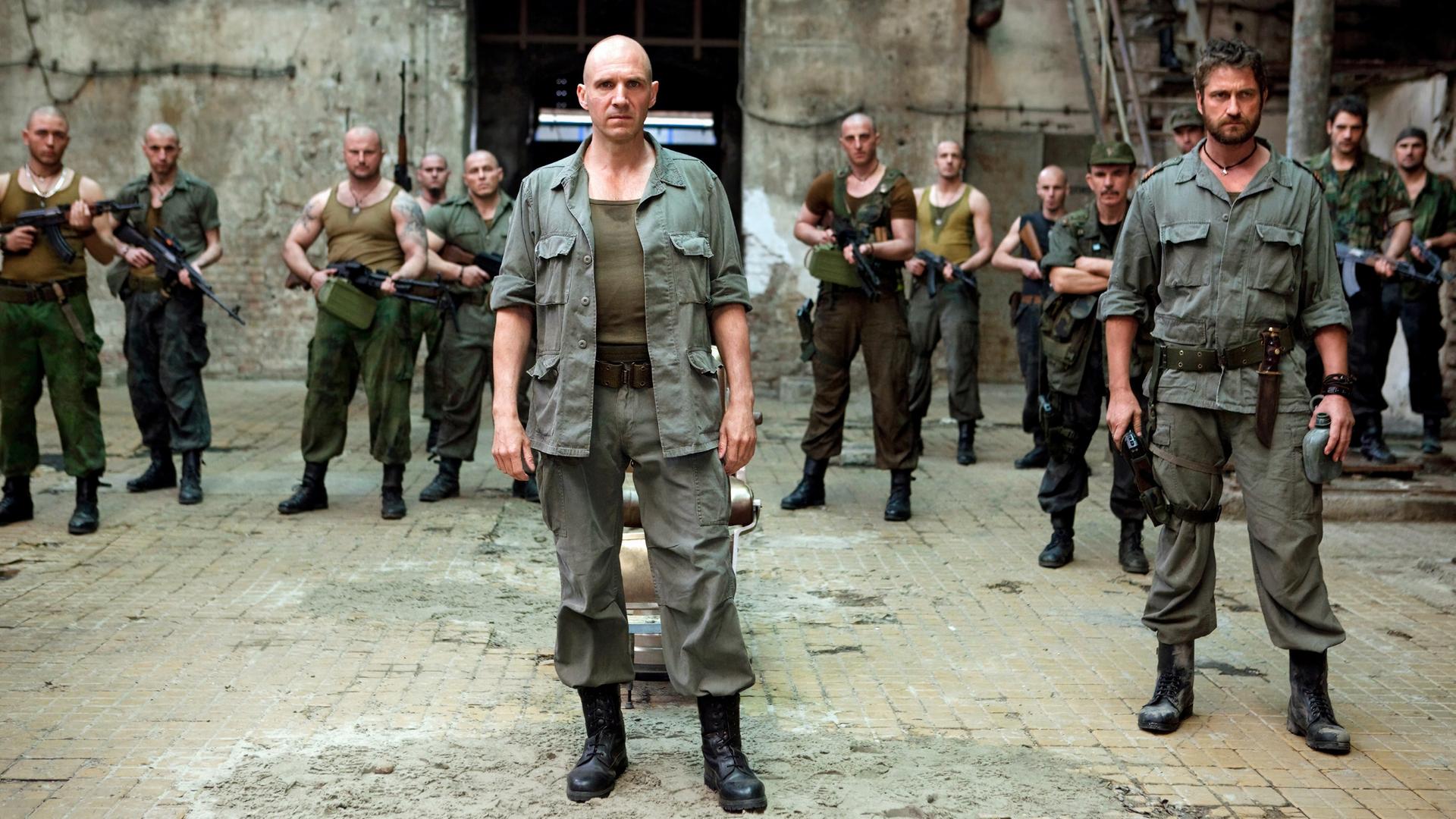 General Coriolanus (Ralph Fiennes, vorne links) und Aufidius (Gerard Butler) stehen in Uniformen vor ihren wartenden Männern.