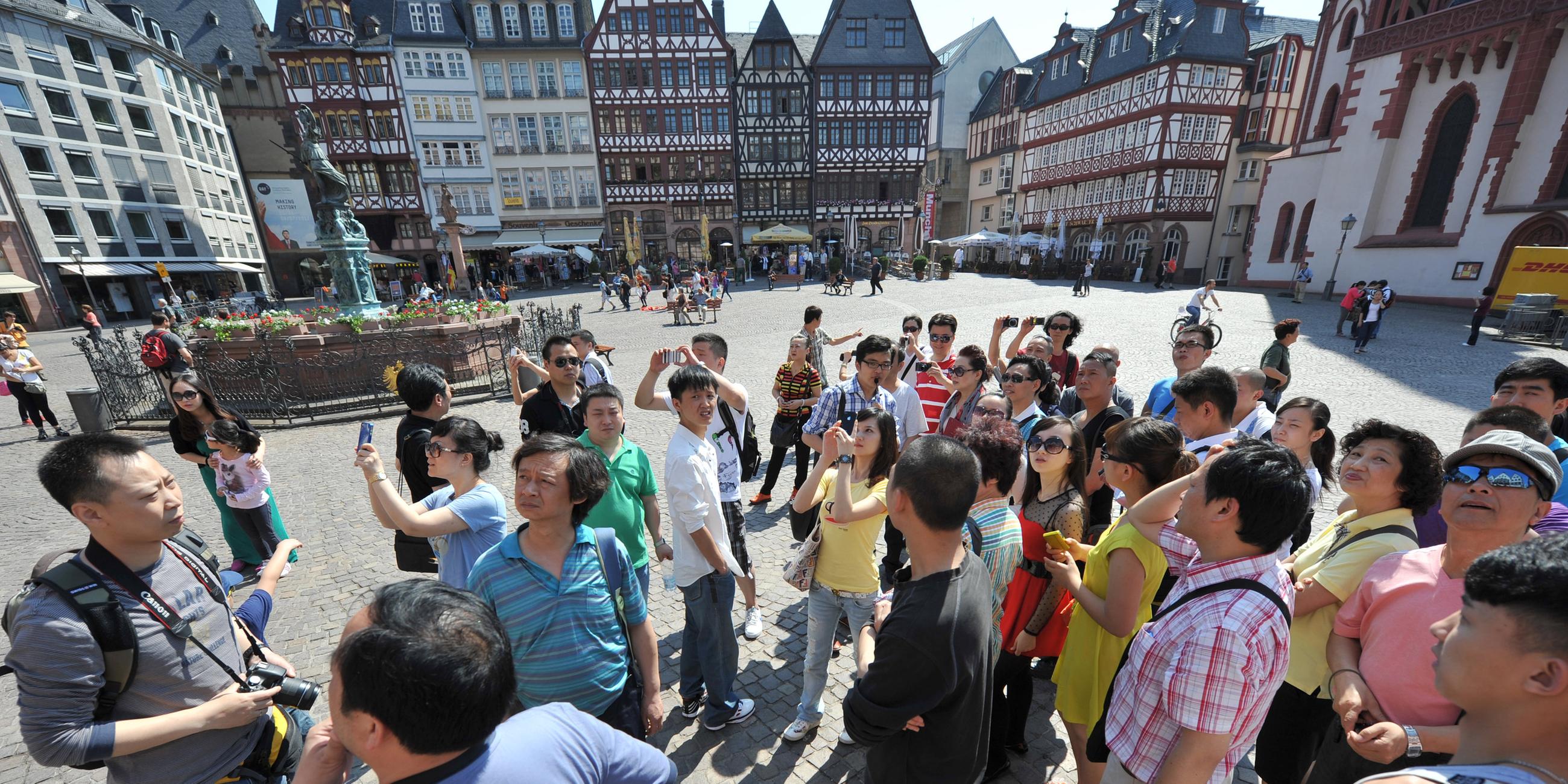 chinesische touristen besichtigen am 24.05.2012 in frankfurt am main den roemerberg mit den fachwerkhaeusern der ostzeil. 