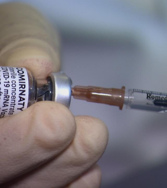 Einem Impffläschchen wird Impfstoff entnommen