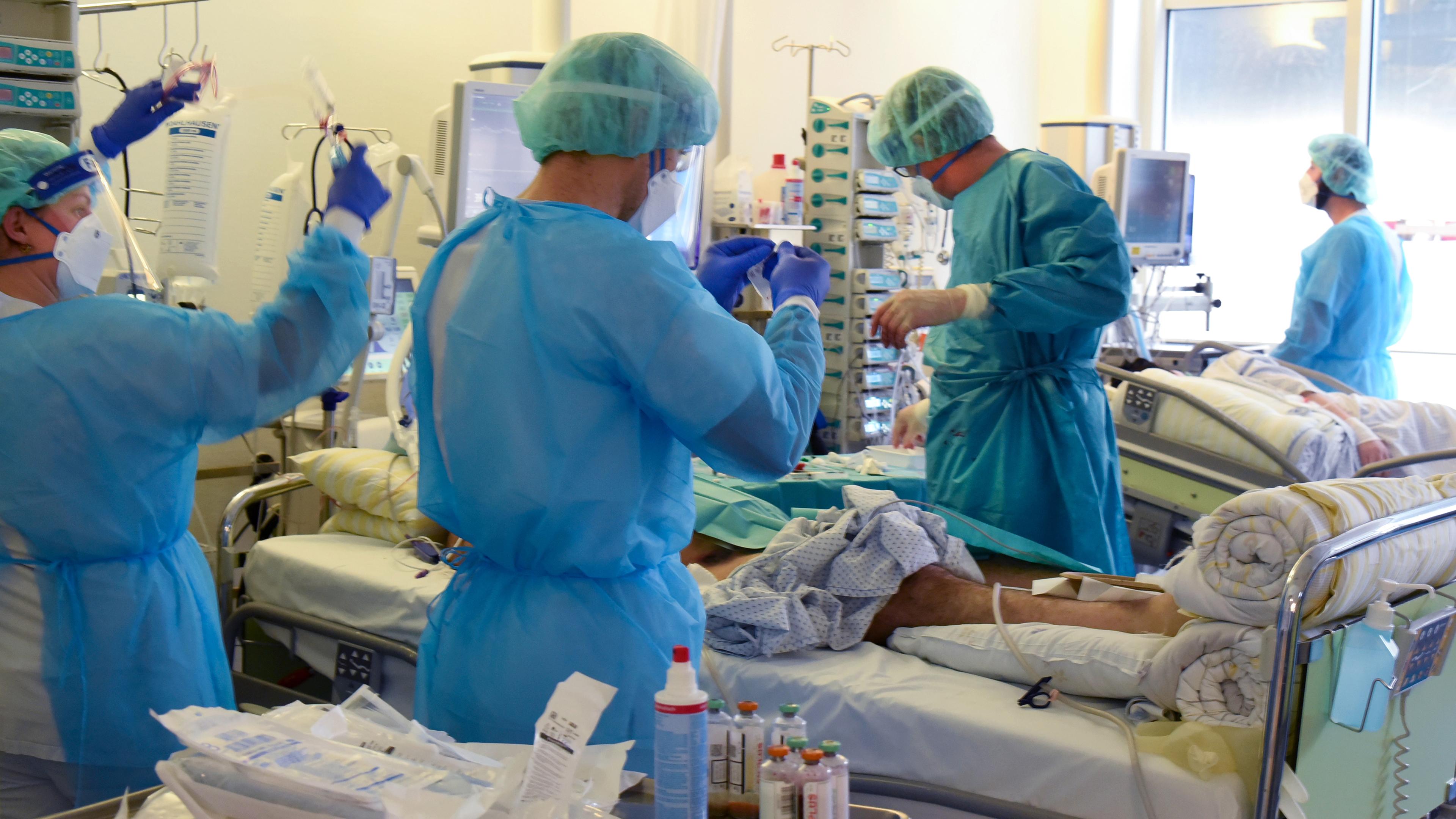 Auf der Covid-Station, einem Bereich der Operativen Intensivstation versorgen Ärzte, Schwestern und Pfleger einen Patienten.