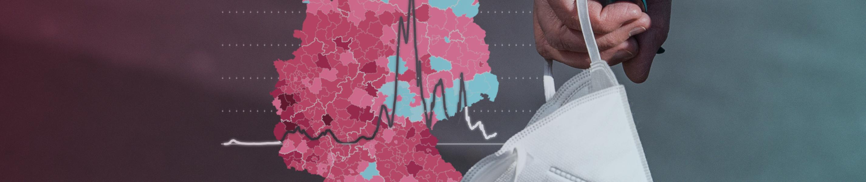 Corona-Karte und Grafik sowie FFP2-Maske in einer Hand gehalten