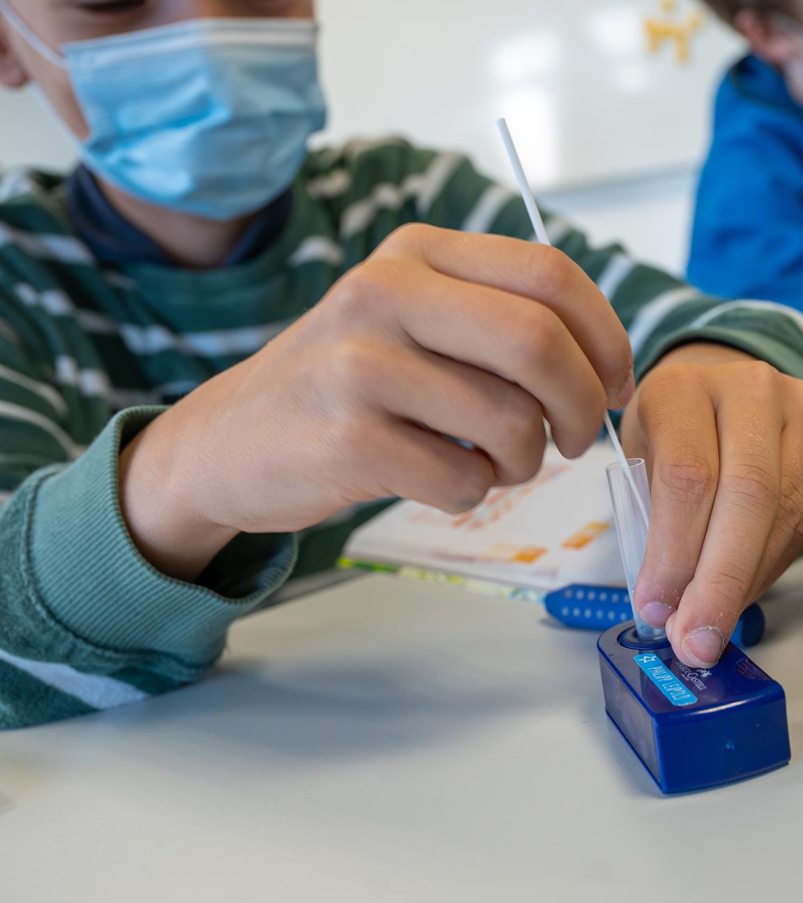 Das Bild zeigt Kinder, die sich auf Corona testen.