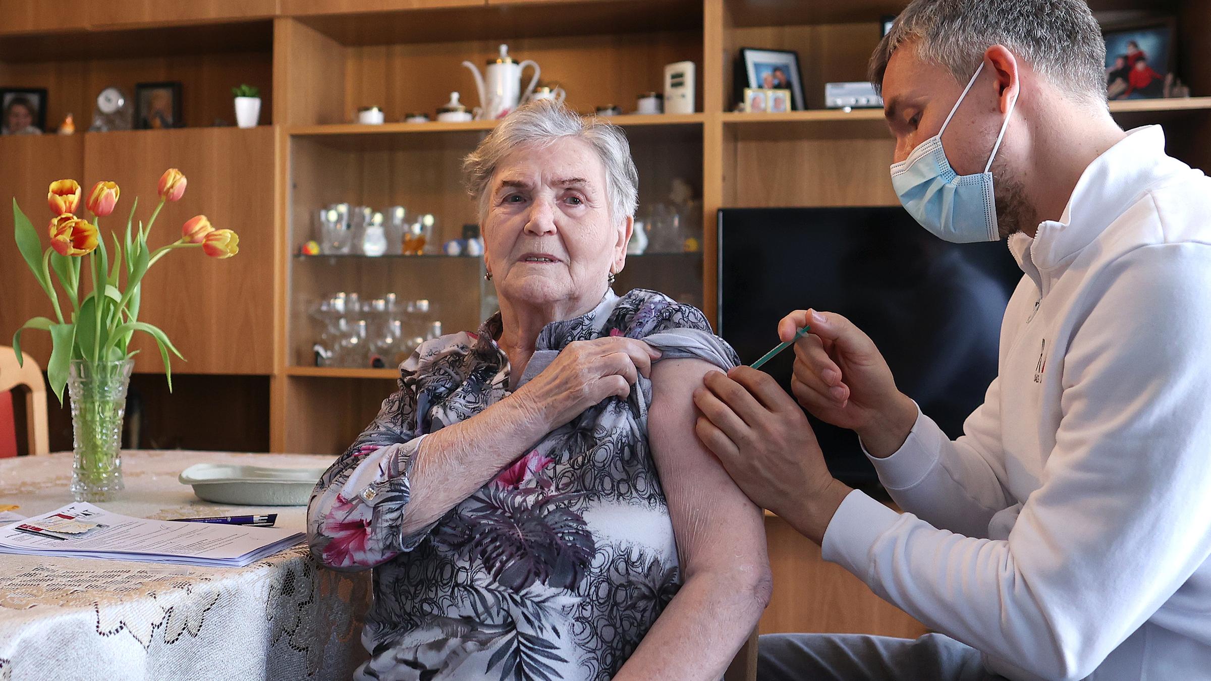 Ein Hausarzt verabreicht einer 84-Jährigen eine Impfung gegen Corona.