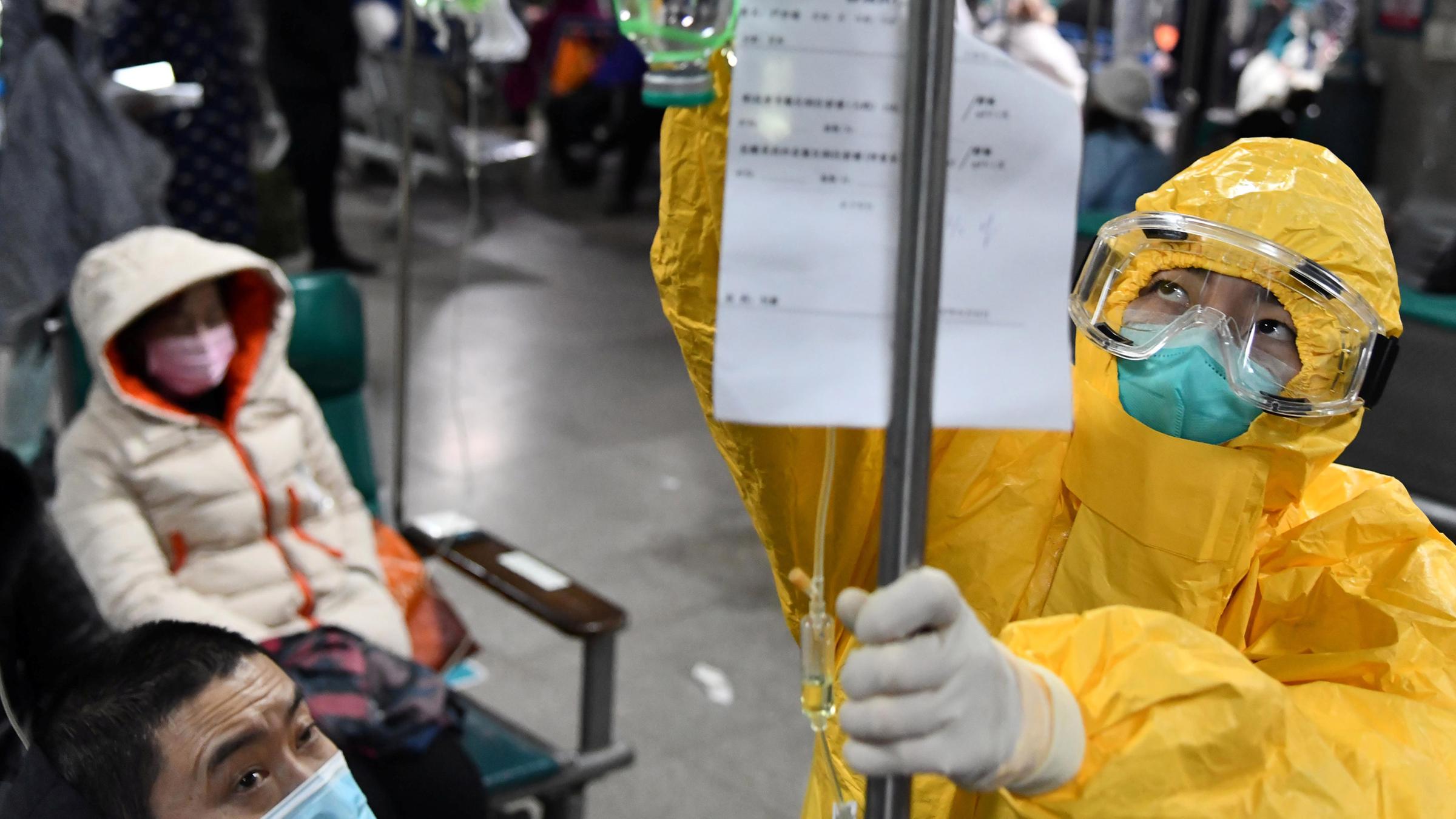 Eine medizinische Fachkraft im Schutzanzug passt setzt einen Tropfbeutel für einen Patienten in einem Krankenhaus am 04.02.2020 in Wuhan.