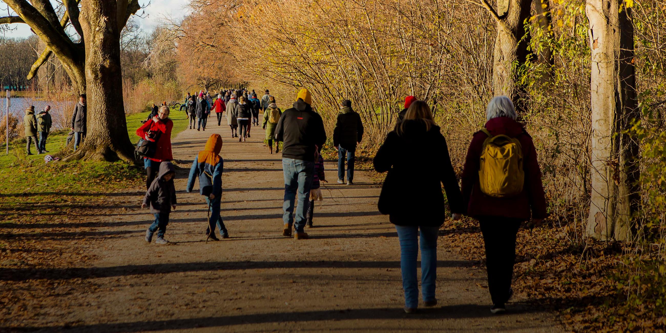 Spaziergänger sind bei strahlendem Sonnenschein und Temperaturen unter 10 Grad am Decksteiner Weiher im Grüngürtel in Köln-Sülz unterwegs.