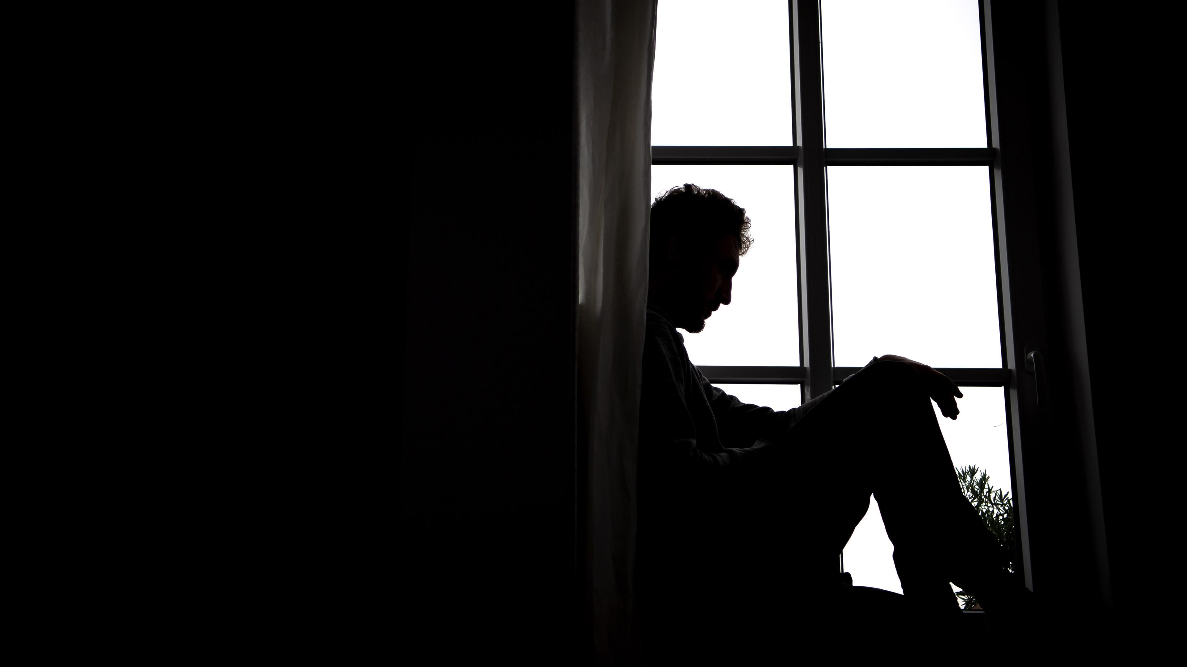 Ein Mann sitzt alleine vor einem Fenster, aufgenommen am 23.03.2021 in Bremen