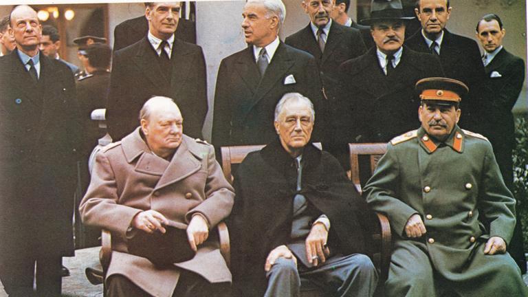 "Countdown zum Kriegsende: Durchbruch im Osten": Winston Churchill, Franklin D. Roosevelt und Josef Stalin sitzen auf Stühlen nebeneinander. Im Hintergrund stehen weitere Herren im Anzug.