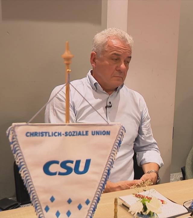 Mitglieder der CSU in Dillingen sitzen an einem Tisch in einer Gaststätte, im Vordergrund steht ein Wimpel mit der Aufschrift "CSU"
