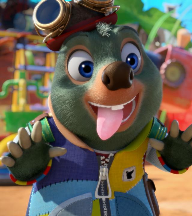 Moley steht mit ausgestreckten Armen und heraushängender Zunge sowie mit gierigem Blick vor einem dick belegten Würmer-Baguette, das ihm eine Hand hinhält.