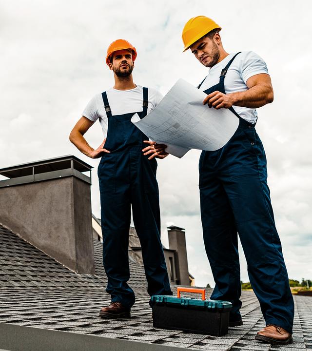 Zwei Männer überprüfen ein Dach eines Hauses