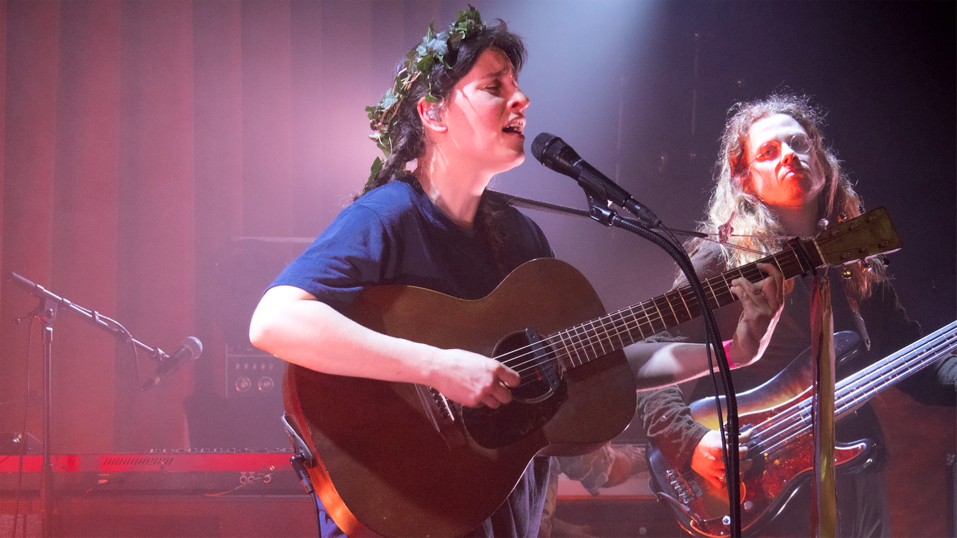 Frontfrau Janine Cathrein steht auf der Bühne mit Gitarre und singend.