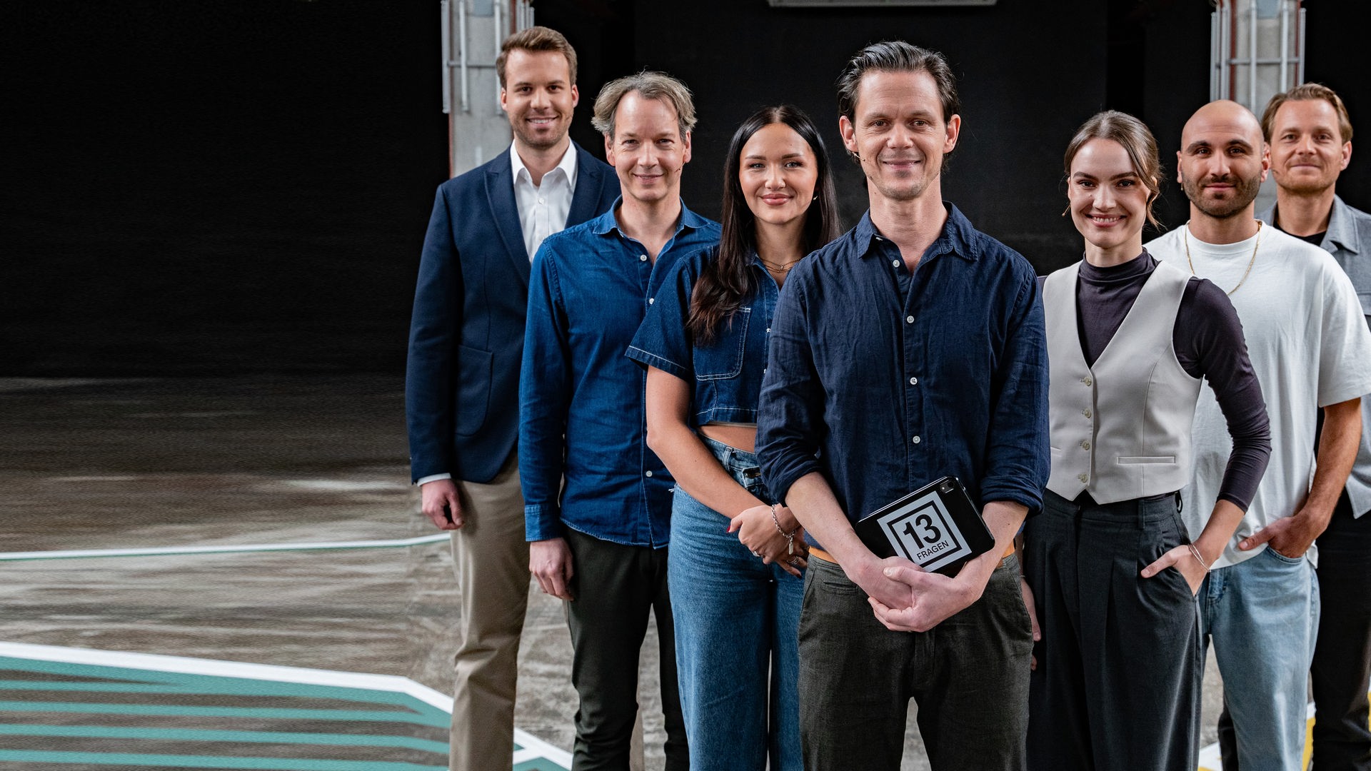 Jo Schück steht mit seinen sechs Gästen auf dem 13 Fragen-Spielfeld.