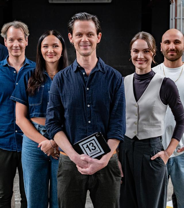 Jo Schück steht mit seinen sechs Gästen auf dem 13 Fragen-Spielfeld.