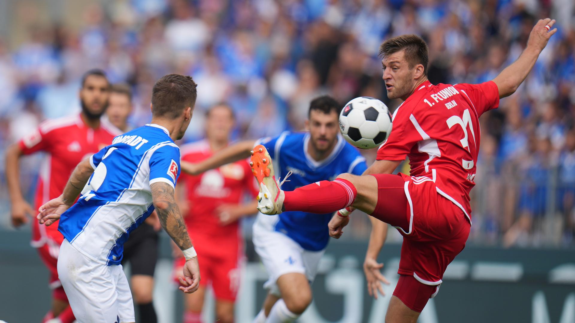 26.08.2023, Hessen, Darmstadt: Fußball: Bundesliga, Darmstadt 98 - 1. FC Union Berlin, 2. Spieltag, Merck-Stadion am Böllenfalltor. Union Berlins Robin Knoche (l) und Darmstadts Marvin Mehlem kämpfen um den Ball.