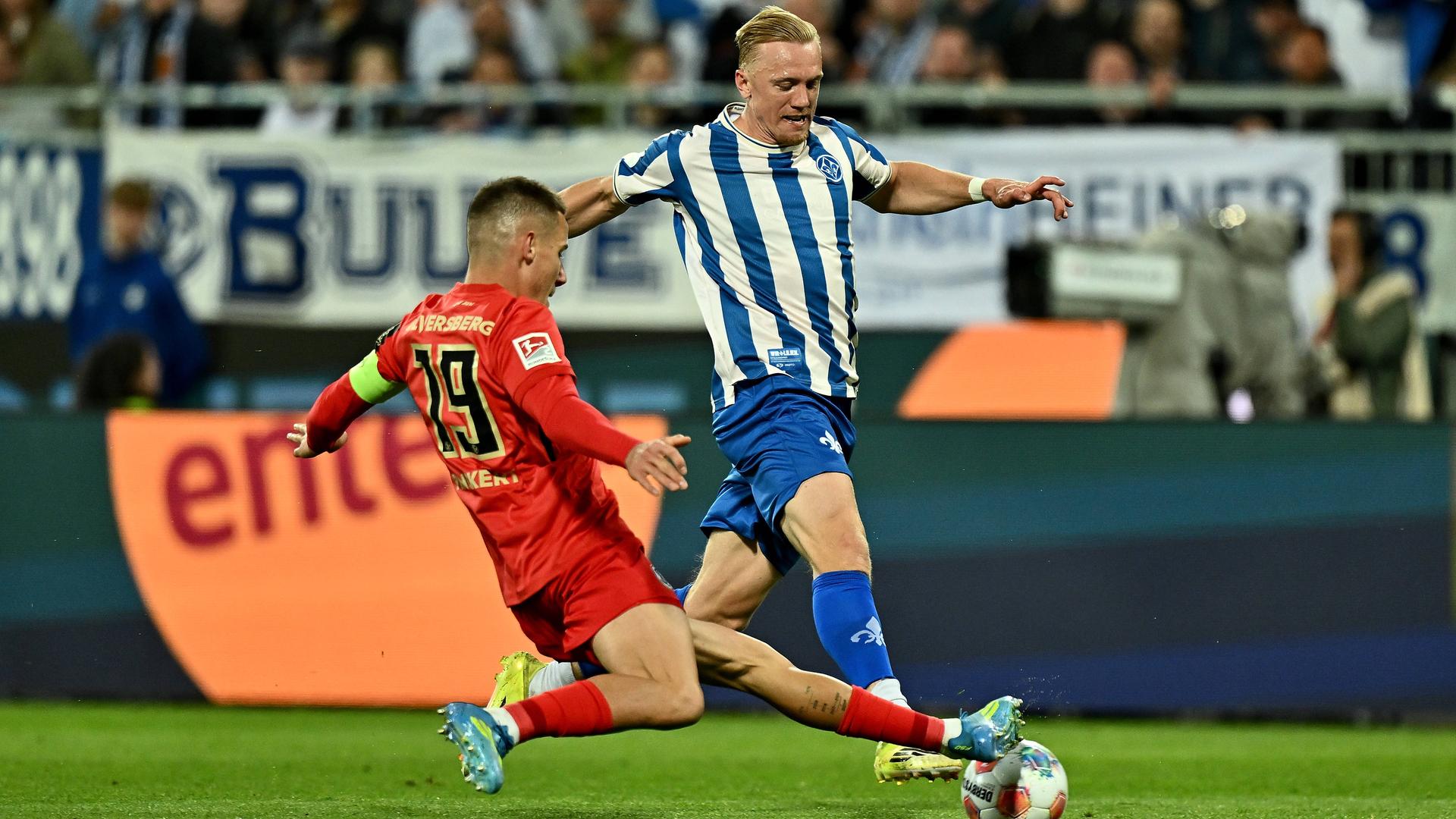 Der Elversberger Innenverteidiger Lukas Pinckert grätscht gegen den ballführenden Darmstädter Mittelfeldspieler Kai Klefisch