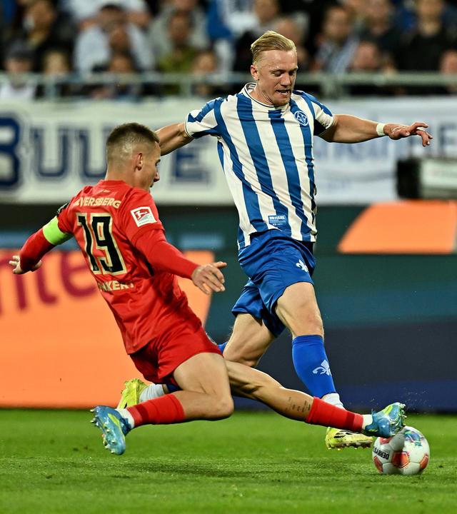 Der Elversberger Innenverteidiger Lukas Pinckert grätscht gegen den ballführenden Darmstädter Mittelfeldspieler Kai Klefisch