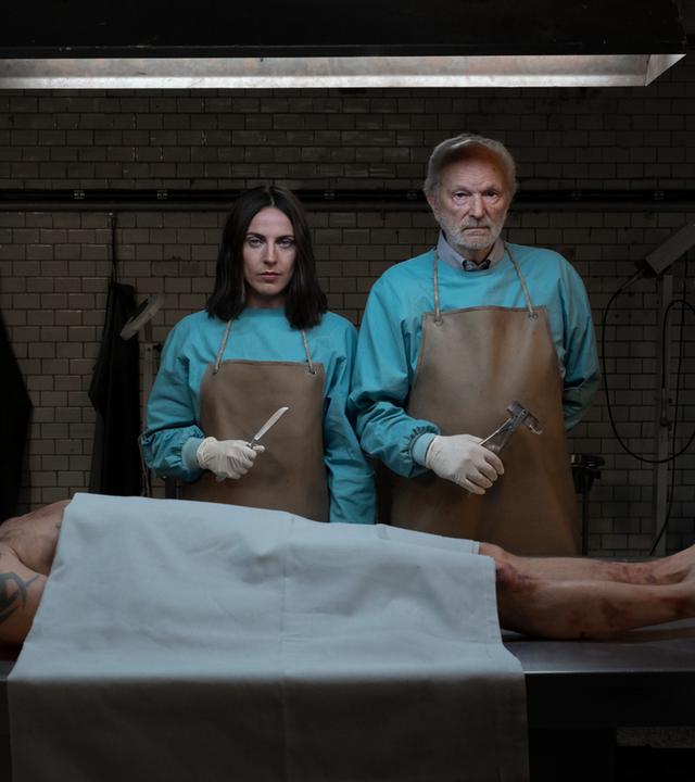 Emma und Peter stehen vor einer obduzierten Leiche