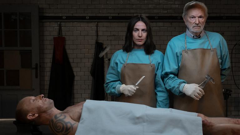 Emma und Peter stehen vor einer obduzierten Leiche