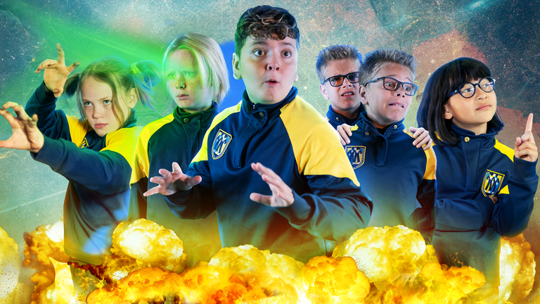 Tele, Raymond, Blaze, Uno als Doppel und Alpha sind in ihrer Schuluniform und wenden ihre Superkräfte an. Von links oben trifft ein grüner Strahl Raymonds Gesicht, unter den Schülern sind Feuerwolken.