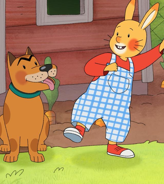 Kaninchenmädchen Monika kniet neben Hund Bello. Kaninchenjunge Karlchen hält in einer Hand ein Stöckchen für Bello.