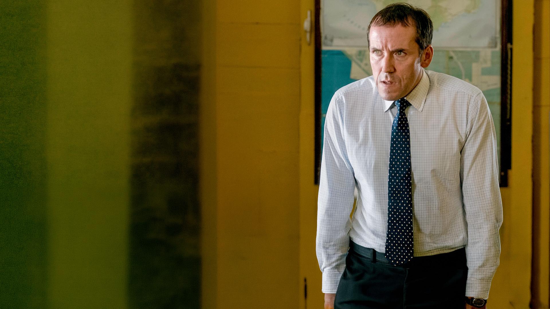 "Death in Paradise - Das Auge des Hurrikans": DI Richard Poole (Ben Miller) stützt sich auf beiden Armen ab und guckt fragend zur Seite.