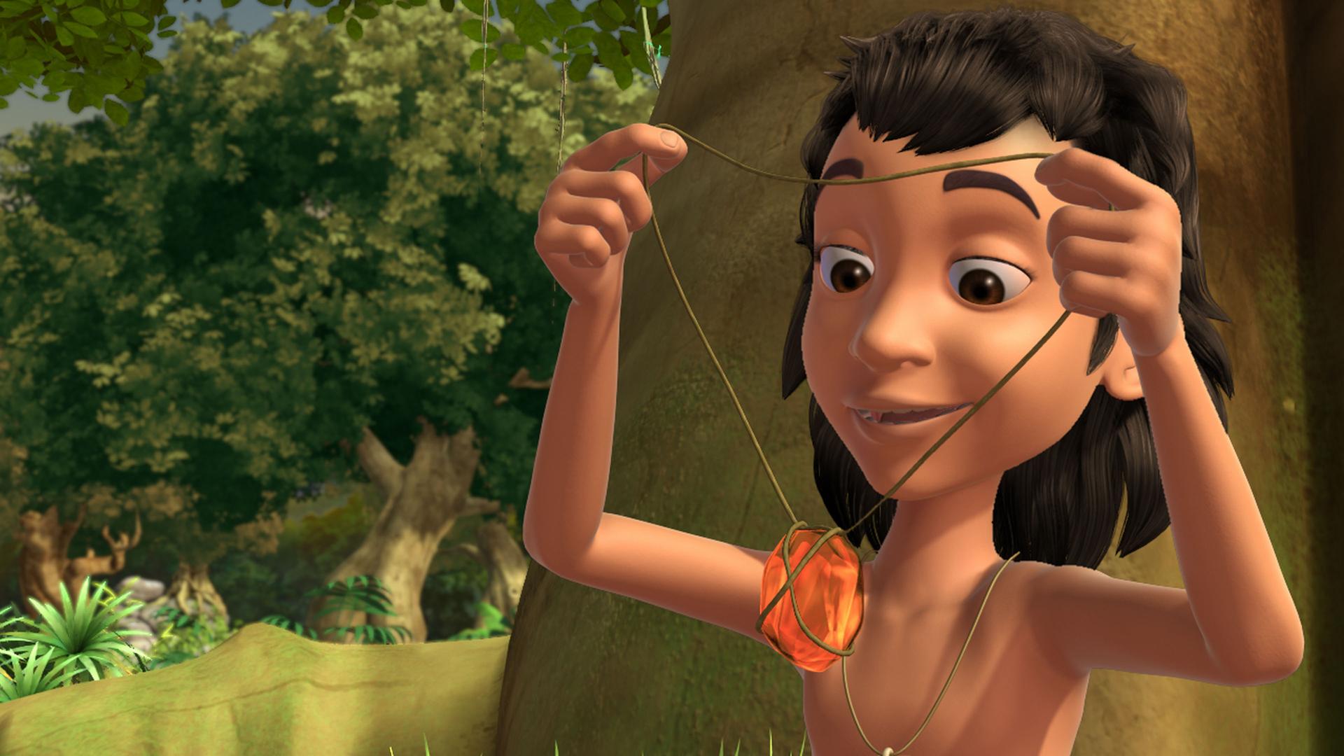 Mogli hält den Bernstein in den Händen.