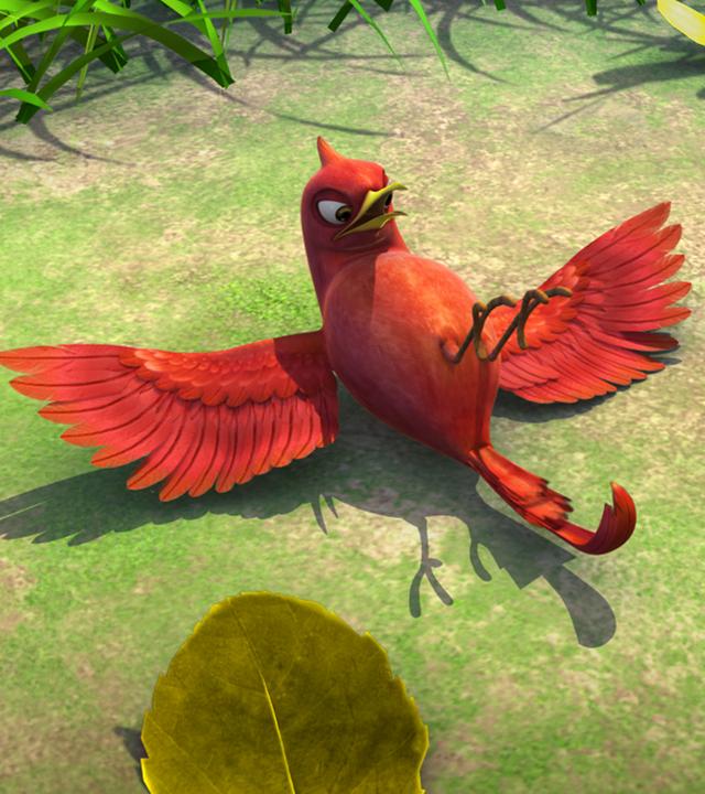 Der rote Vogel Darsi liegt auf dem Rücken auf einer Wiese.