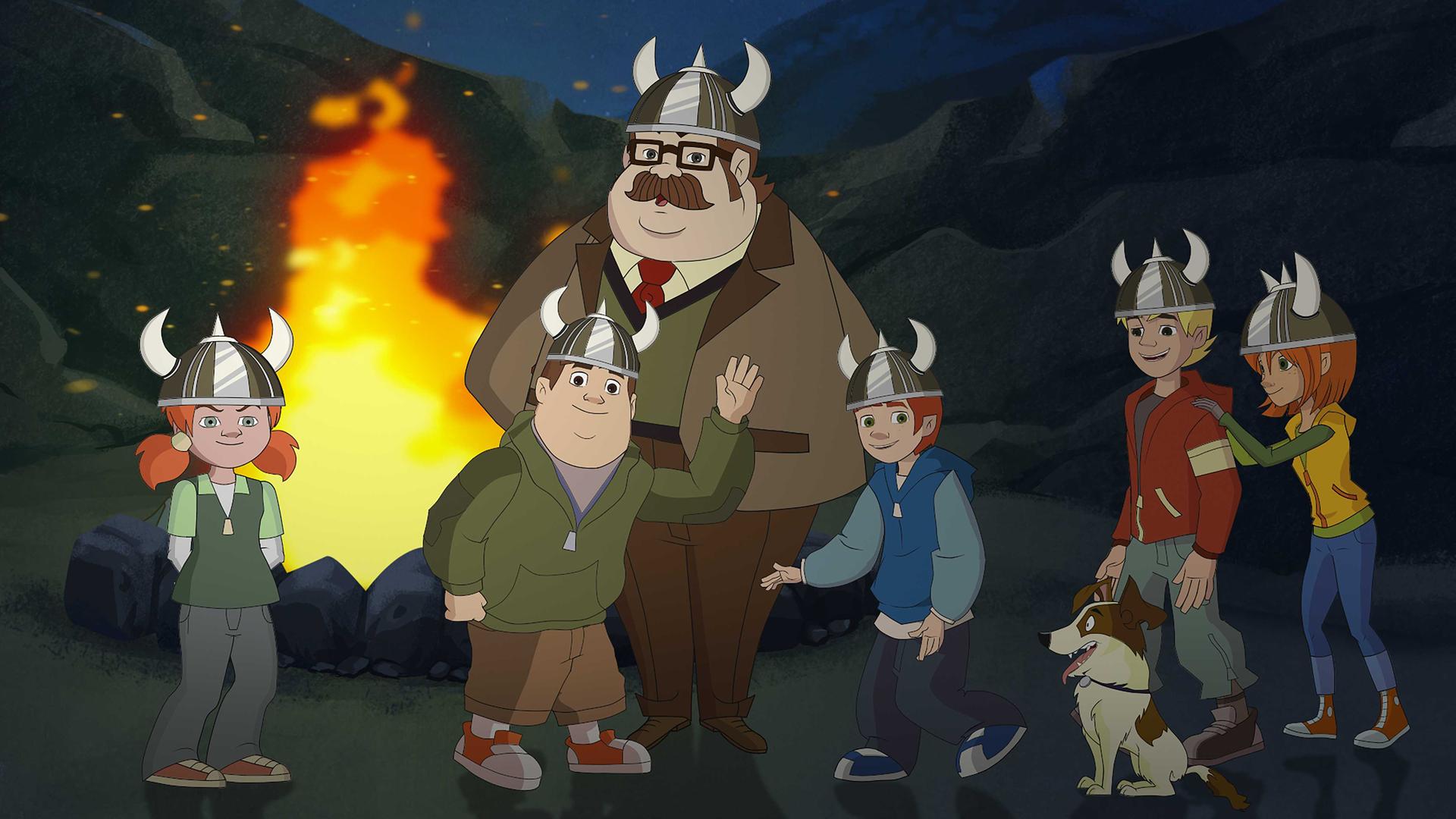 Die Freunde und Herr Schlüter stehen vor einem Lagerfeuer und tragen Wikingerhelme. Sie sehen alle gut gelaunt aus.