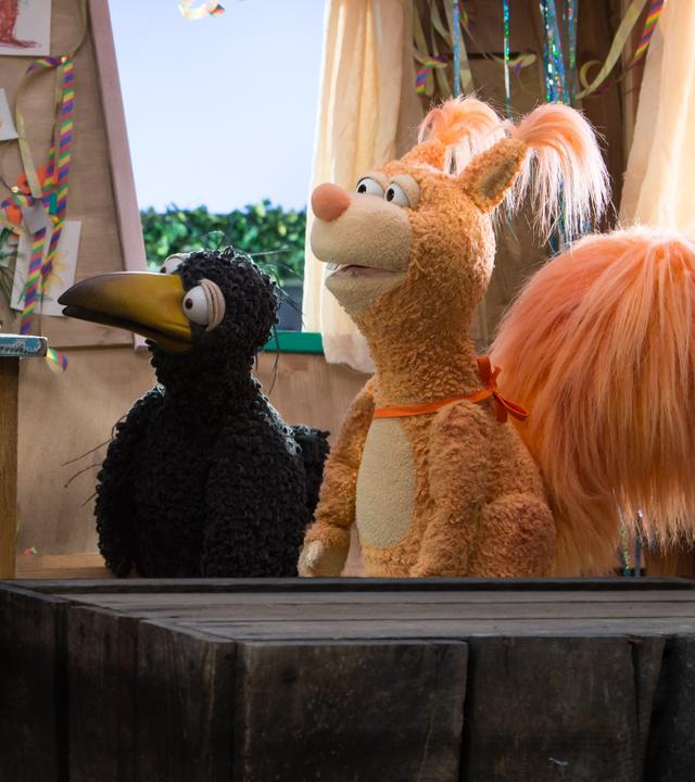 Rabe Rudi, Ella Eichhörnchen und Hund Buffo schauen sich an.