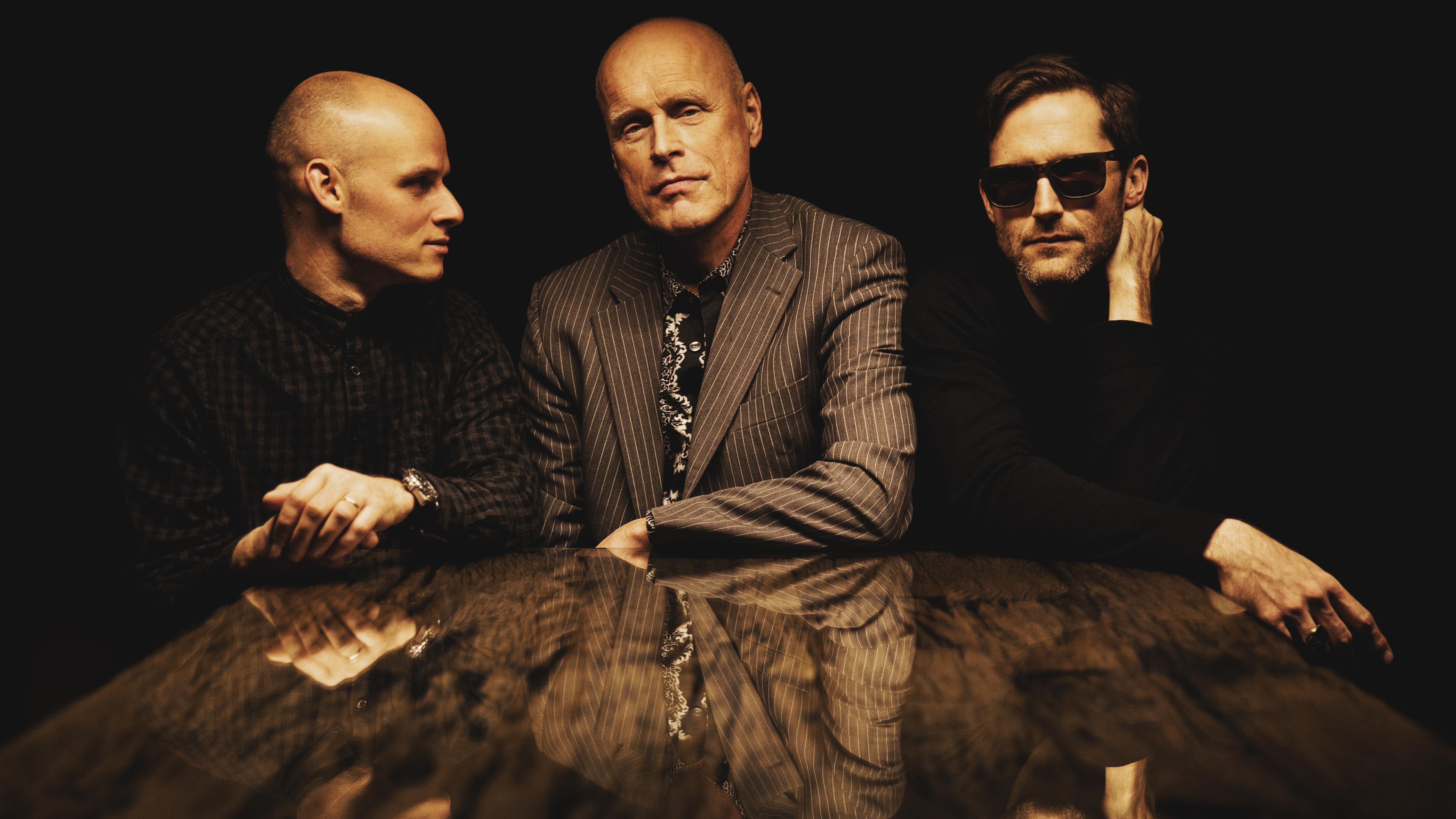 Das Jazztrio das Kondensat an einem Tisch.