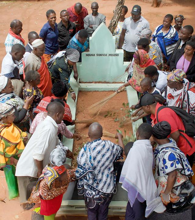 John Mbano, Aidan Mbano und ihre Familie gedenken dem ermordeten Songea Mbano an dessen Grab.
