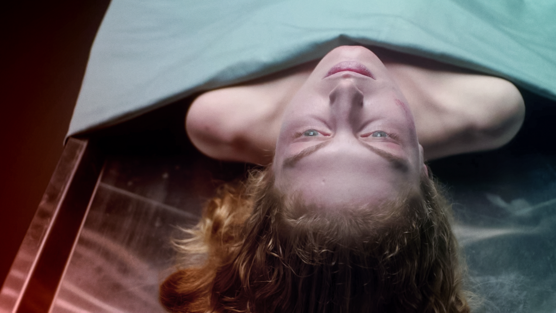 Eine Leiche, deren Kopf und Schulterpartie unter einem Tuch hervorragen, liegt auf dem Obduktionstisch.