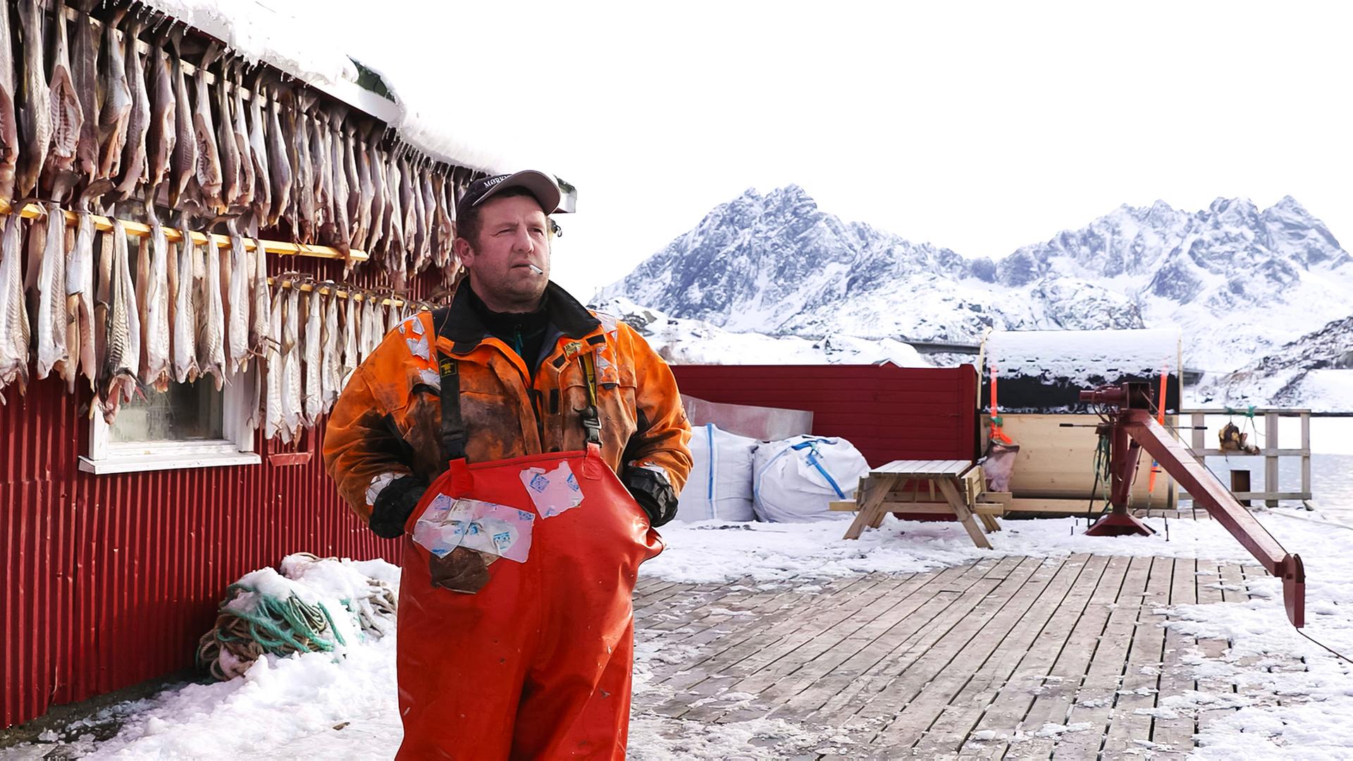 Ein Fischer auf einer Insel im norwegischen Eismeer vor seinem Fang.