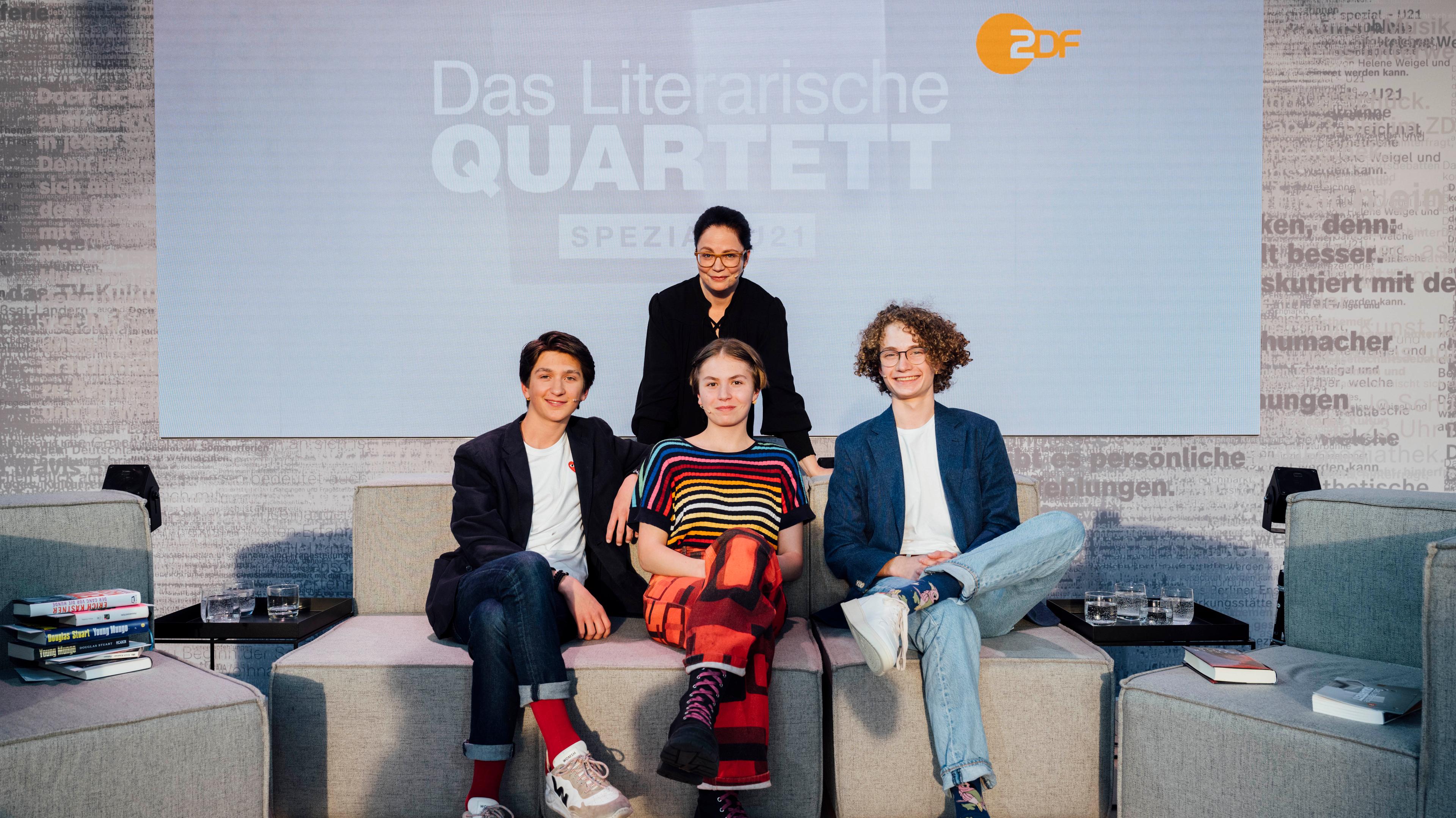 Die 3 jungen Literaturfans. Thea Dorn dahinter. Auf ZDF/3sat-Lesebühne. Hintergrund Logo im Monitor 