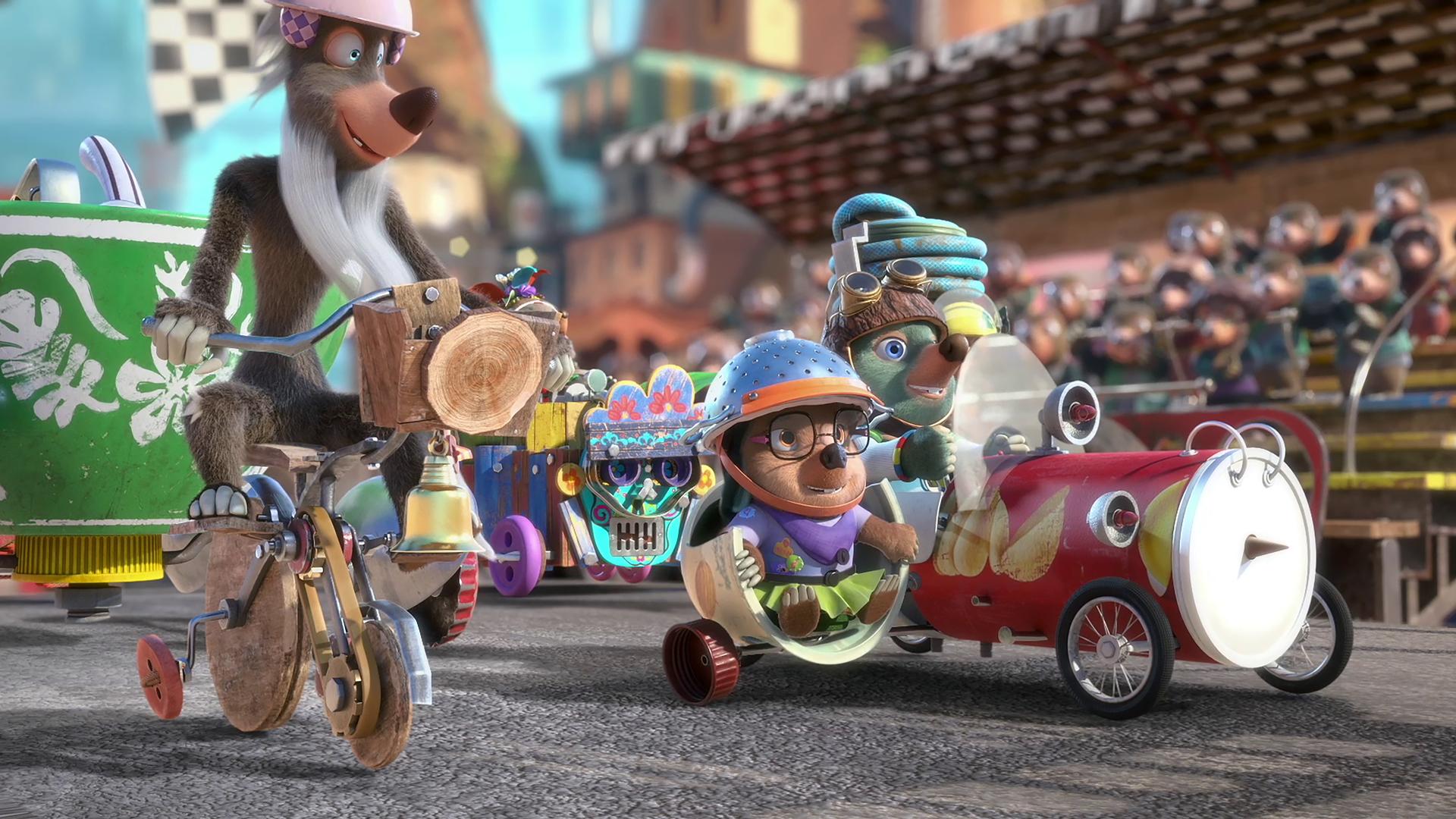 Moley und Dotty sitzen in ihrem selbstgebastelten Rennauto an der Startlinie und warten auf den Startschuss für das Rennen. Um sie herum stehen andere Fahrzeuge. Im Hintergrund sieht man eine Tribüne mit Zuschauern.