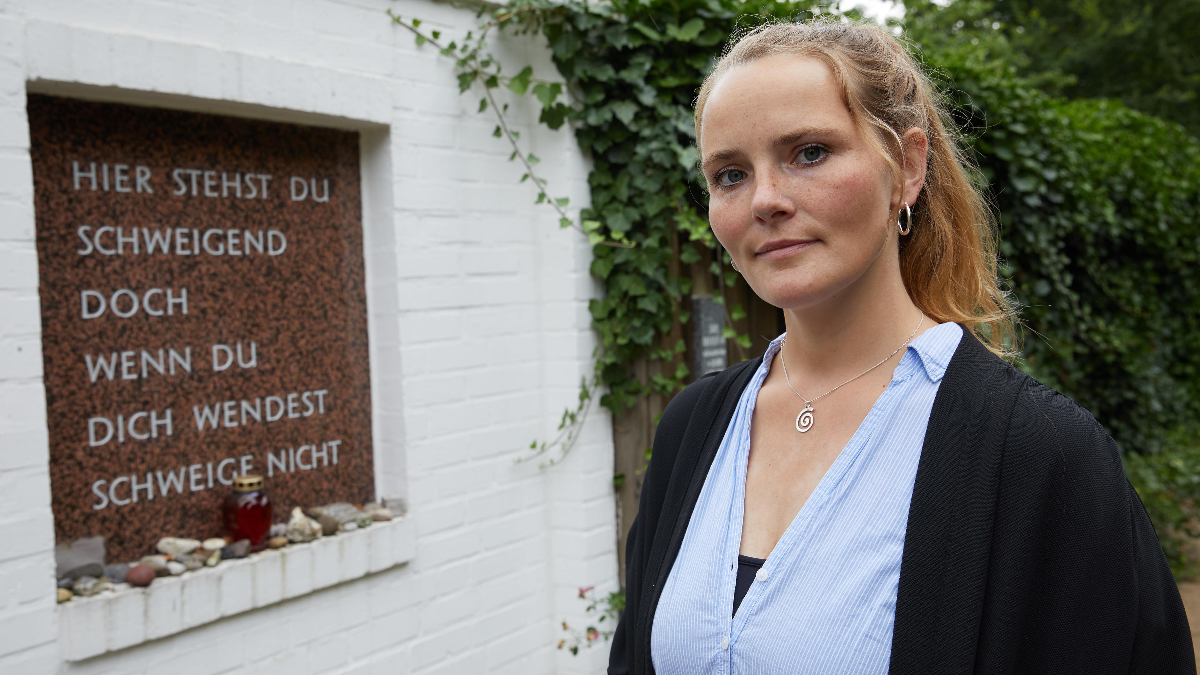 "Das Nazi-Erbe - Trauma, Schuld, Verantwortung": Maria Holzgrewe vor der Gedenktafel im Rosengarten der Gedenkstätte "Bullenhuser Damm" in Hamburg.