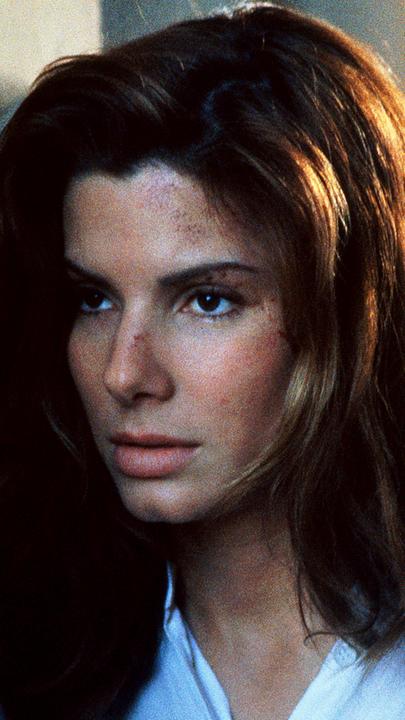 Angela Bennett (Sandra Bullock) ist auf der Flucht. Ratlos steht sie an einem öffentlichen Fernsprecher und hält desillusioniert den Hörer in der Hand.