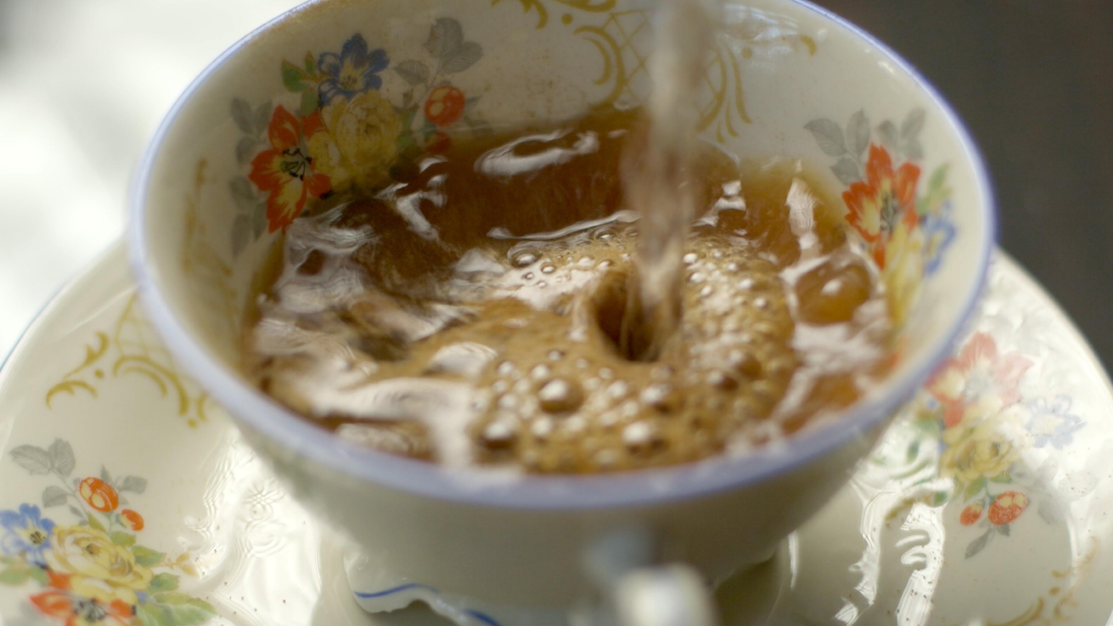 In eine alte Kaffeetasse mit Blümchenmuster wird auf Kaffeeersatzpulver Wasser gegossen.