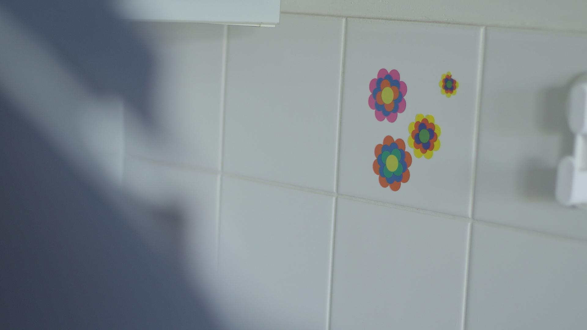 Prilblumen kleben auf weißen Fliesen.