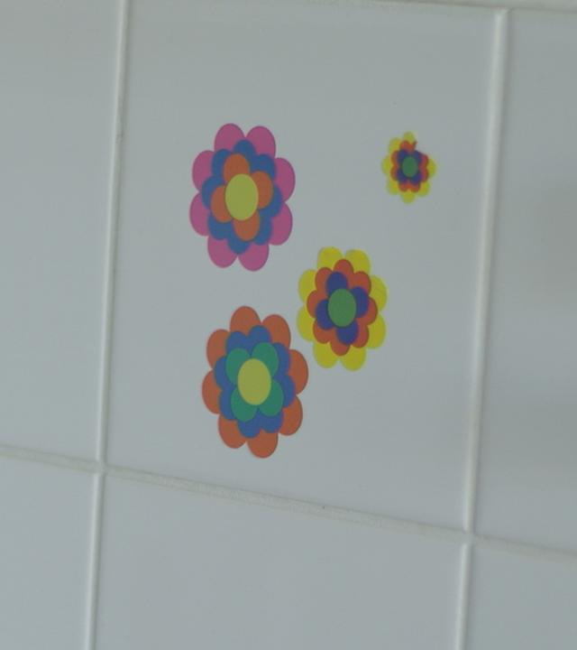 Prilblumen kleben auf weißen Fliesen.