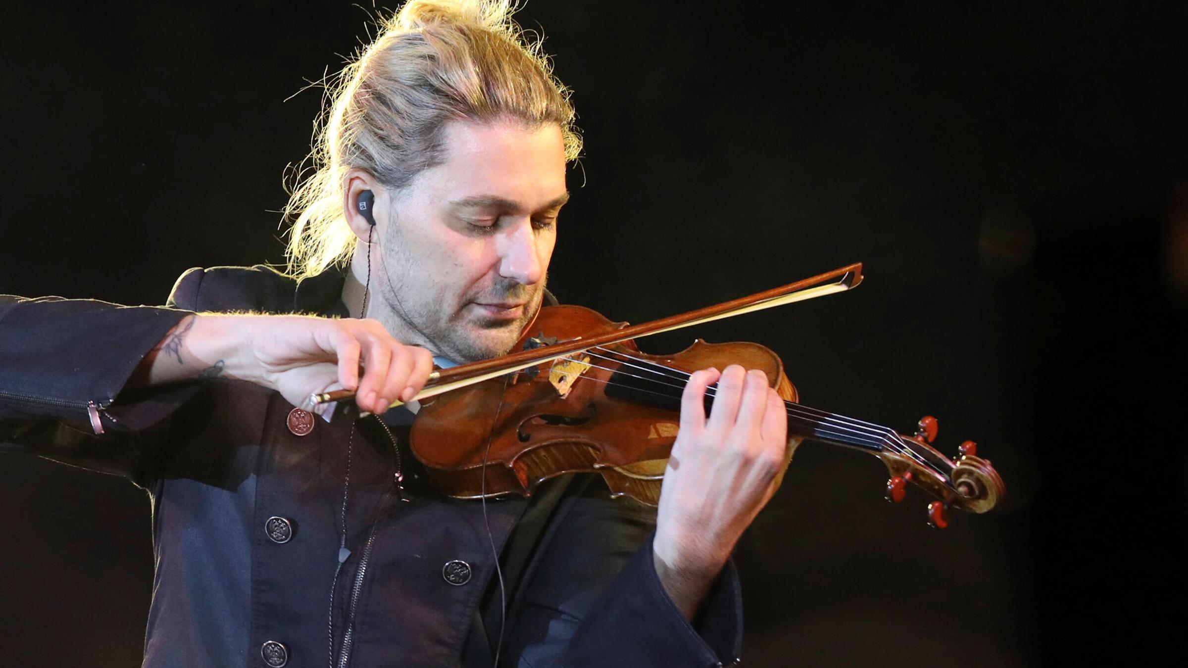 Stargeiger David Garrett im Profil. Er hält die Geige über seine Schulter