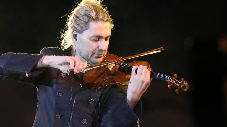 Stargeiger David Garrett im Profil. Er hält die Geige über seine Schulter